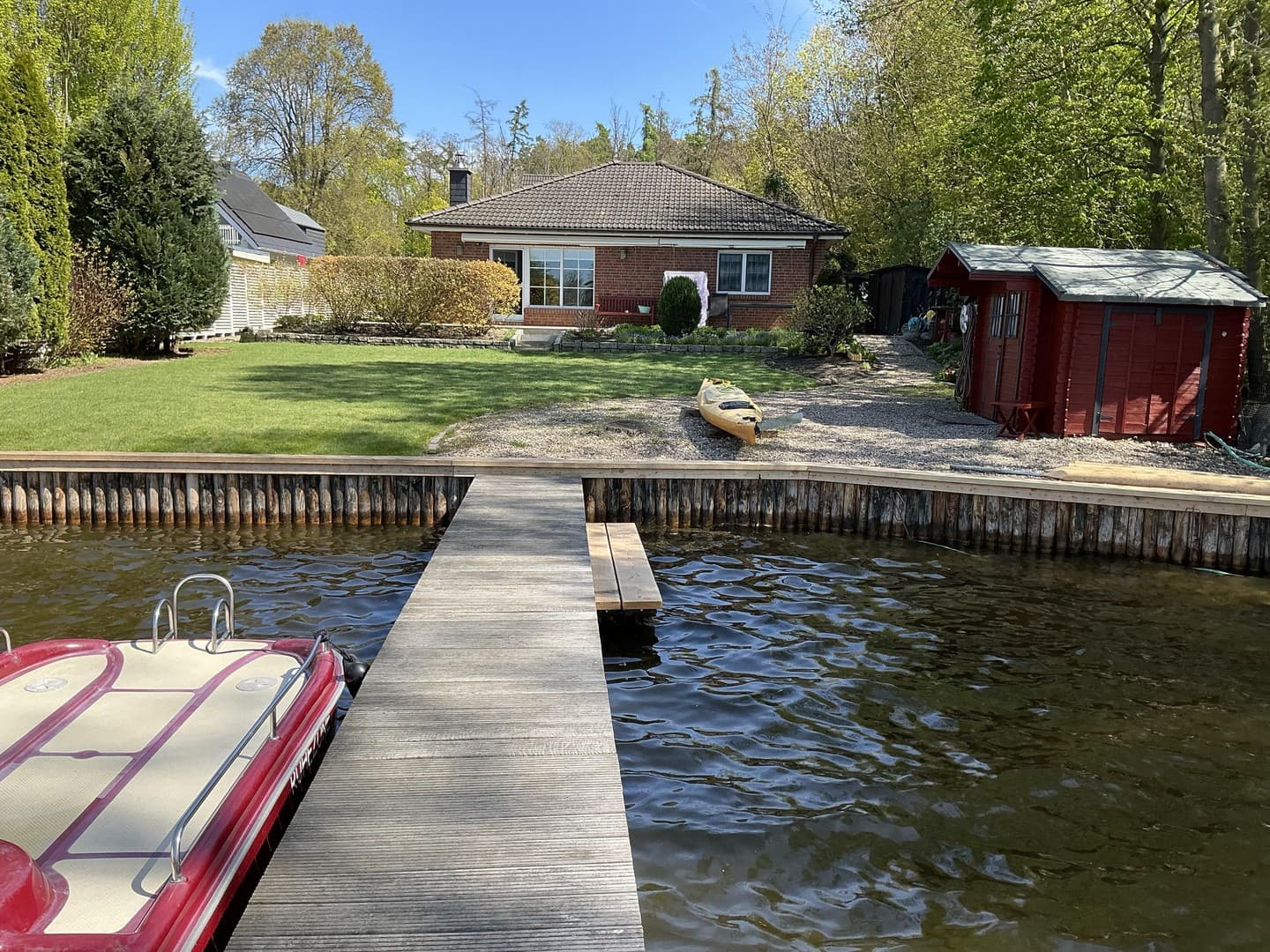 Wassergrundstück mit Bungalow und Bootssteg.