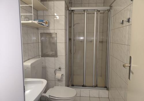 Das Badezimmer mit integriertem Föhn und einer Dusche, WC, und Waschbecken