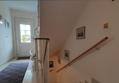 Der Eingangsbereich und das gepflegte Treppenhaus mit Treppenlift zum 1. OG