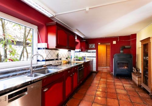 Die offene Wohnküche mit Einbaugeräten und Schwedenofen