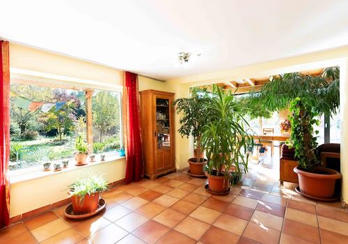 Das geräumige Wohnzimmer im Erdgeschoss mit Zugang zu Wintergarten und Küche