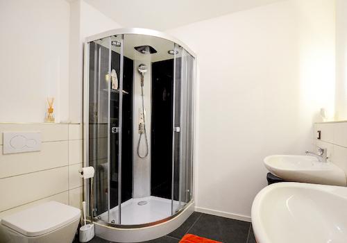 Das großzügige Duschbad mit Glasdusche, WC, 2 Waschbecken und Waschmaschinenanschluss