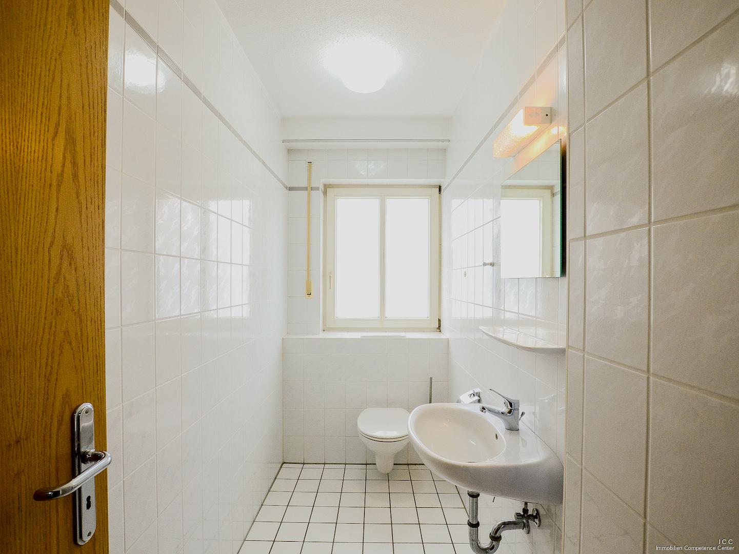 Eines der Gäste-WCs mit Waschbecken und Fenster