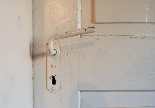 Die originale Holztür zu einem der Zimmer im Obergeschoss