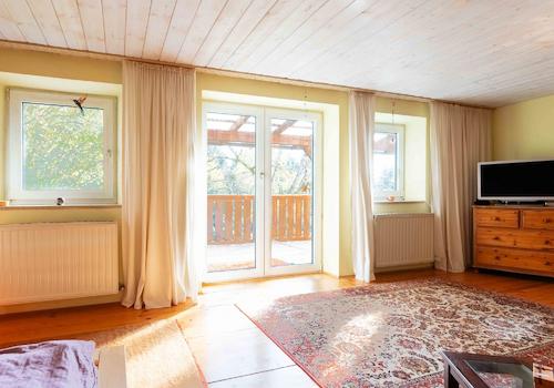 Die weitere Ansicht auf das Schlafzimmer mit viel Tageslicht und Zugang zum Balkon