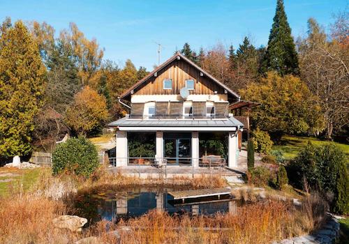 Die Südseite des Hauses mit Ansicht auf den Wintergarten und den Teich