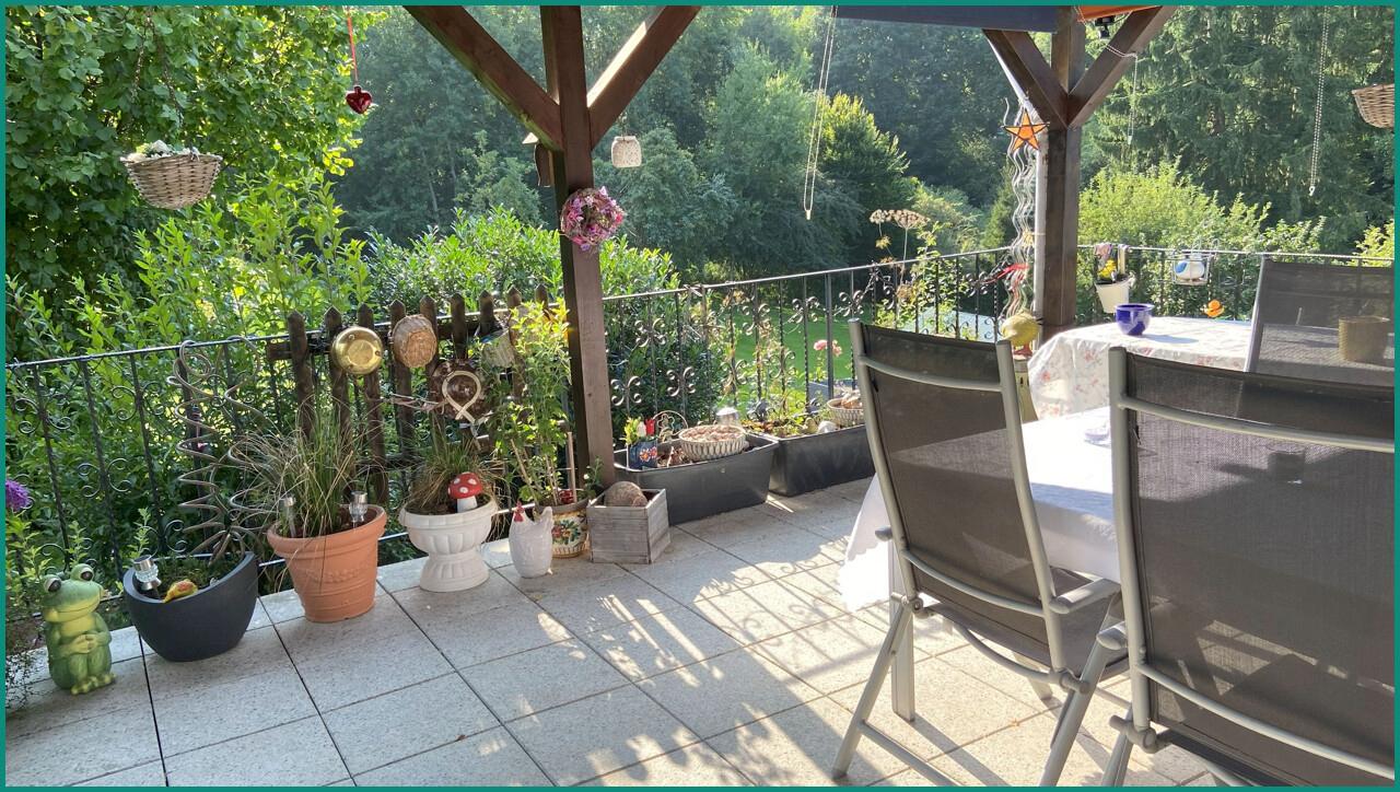 Große überdachte Terrasse mit Panoramablick ins Grüne
