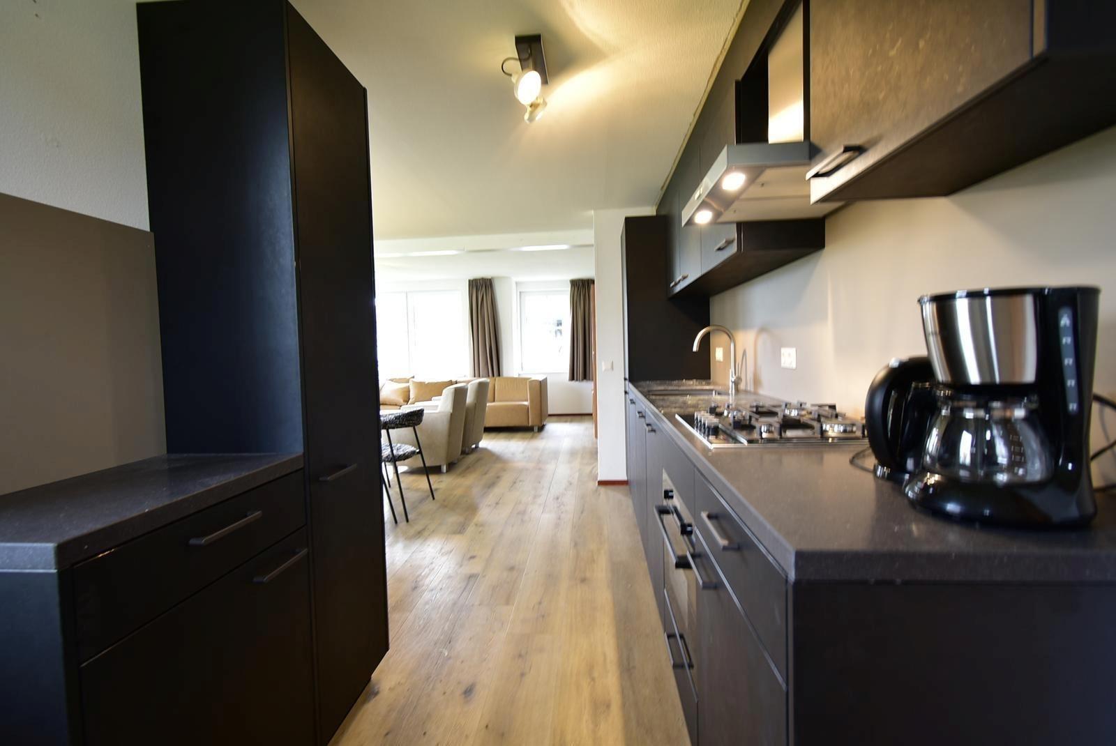 ferienhaus-kaufen-ferienresort-cochem-cochem-niederlande-lange-kuche-mit-blick-wohnzimmer-2025