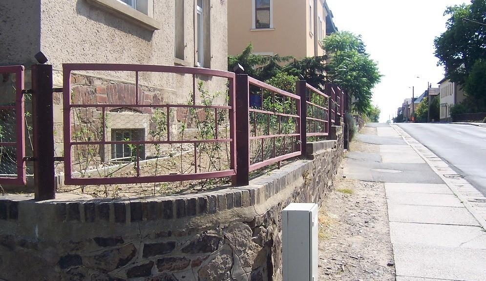 Natursteinmauer mit Eisenzaun
