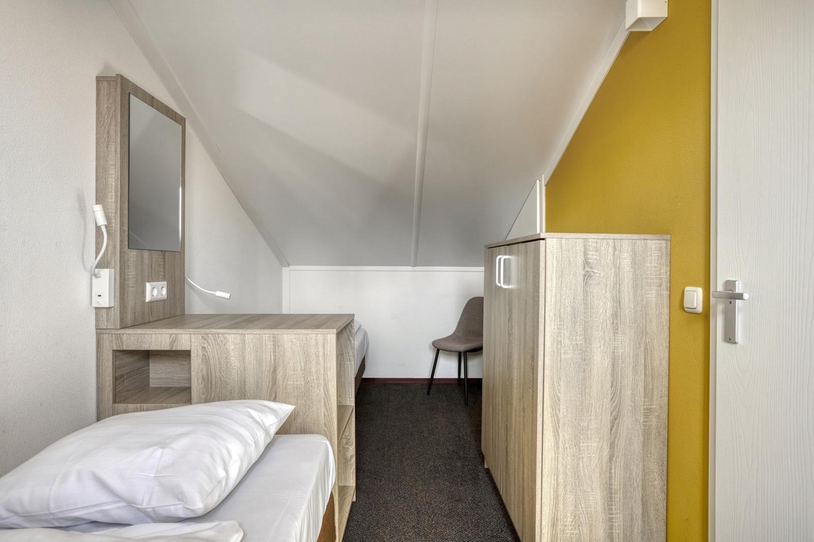 hauptschlafzimmer-kaufen-duinresort-gelbe-wand-doppelbett03