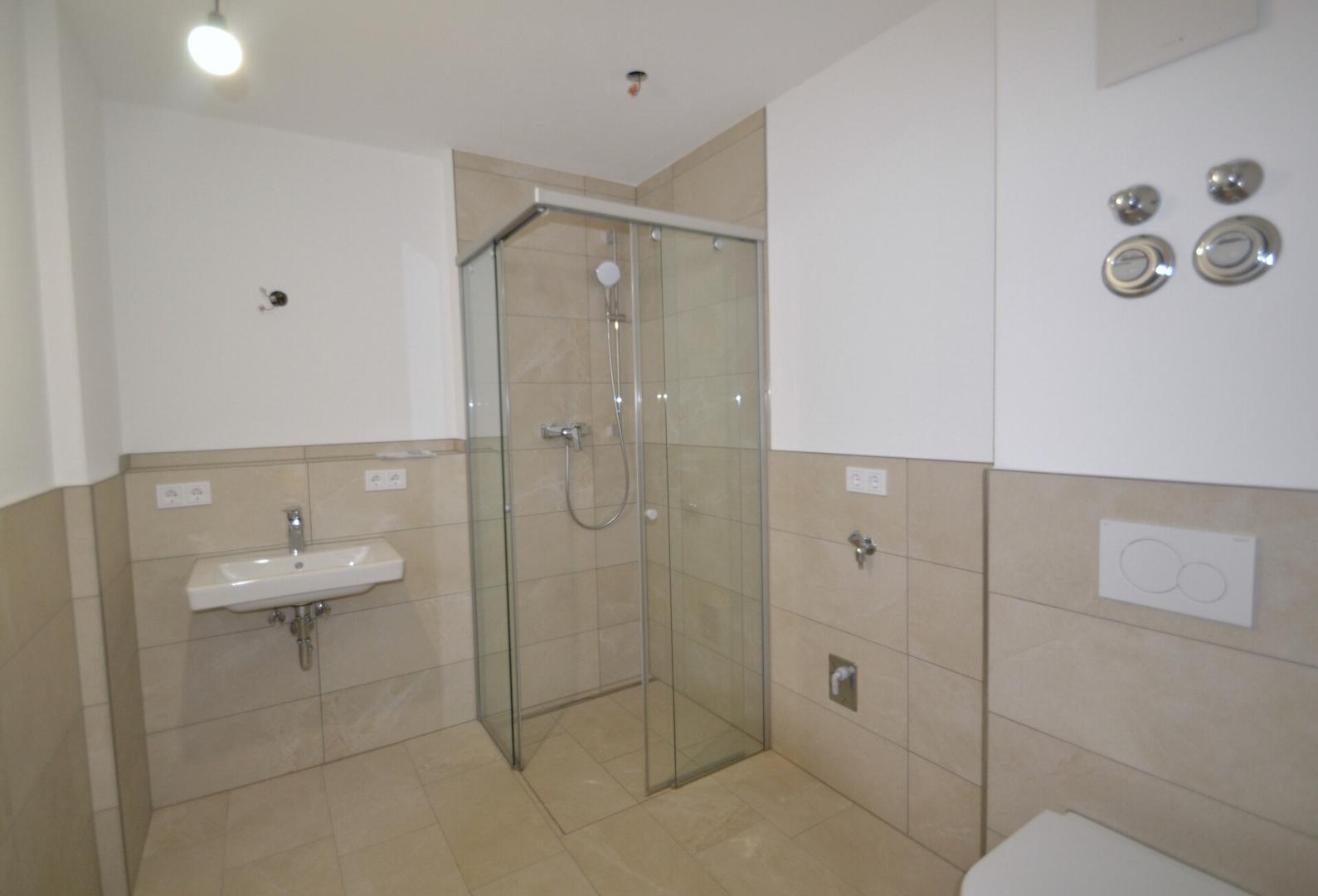 Badezimmer mit ebenerdiger Dusche und Waschmaschinenanschluss