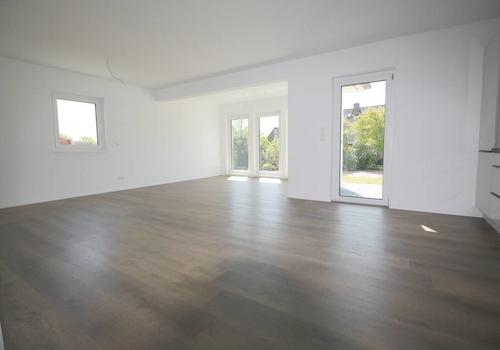 Blick in den Wohnbereich mit bodentiefen Fenstern u. Terrassenzugang