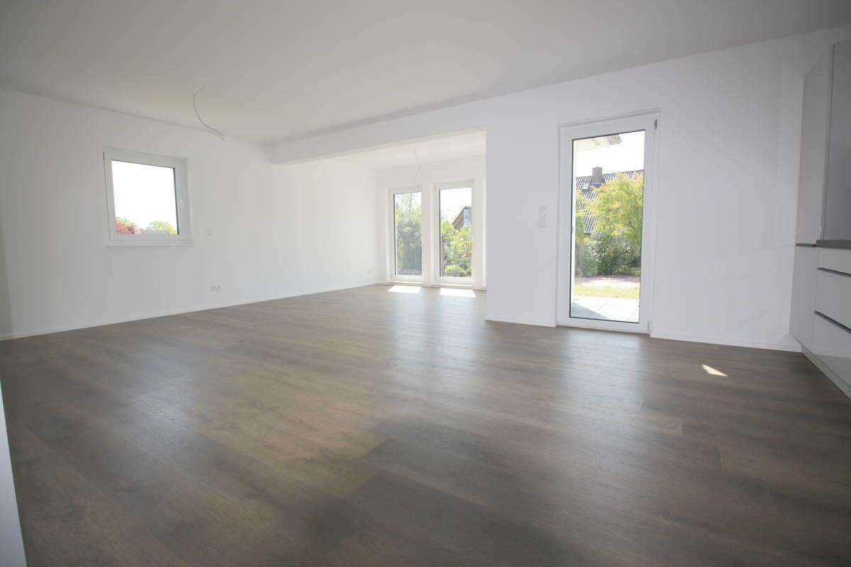 Blick in den Wohnbereich mit bodentiefen Fenstern u. Terrassenzugang