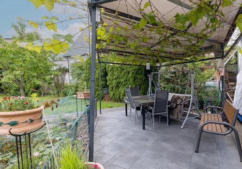 Überdachte Terrasse mit Blick ins grüne Gartengrundstück