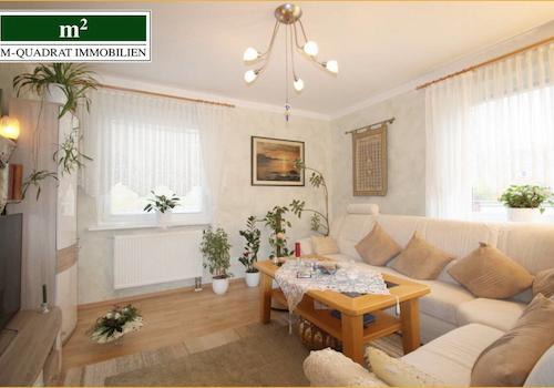 Wohnzimmer mit zwei großen Sonnenfenstern