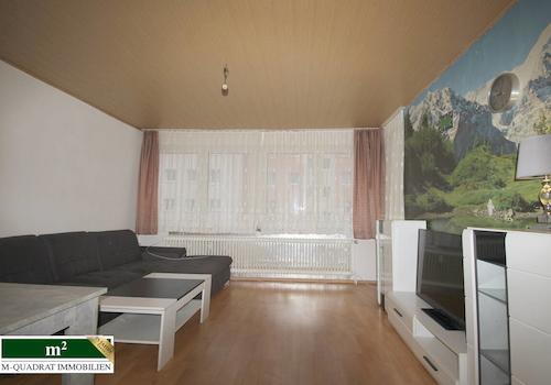 Wohnzimmer mit Panoramafenster und Loggiazugang