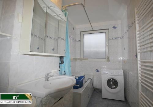 Badezimmer mit Wanne und Waschmaschine
