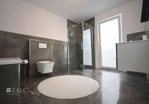 „Stilvolles Badezimmer mit Badewanne, Dusche und exklusiver Fliesengestaltung.“