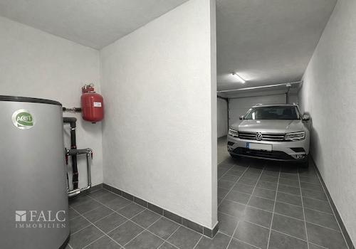 „Garage mit separatem Heizungsraum, aktuell baubedingt mit Material belegt – Visualisierung.“