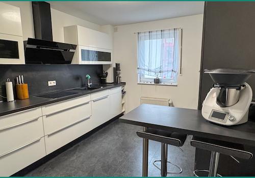 Moderne Einbauküche mit kleiner Esstheke und...