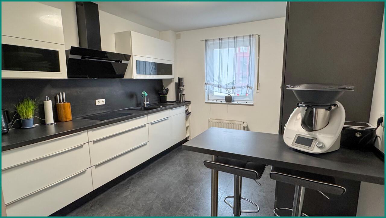 Moderne Einbauküche mit kleiner Esstheke und...