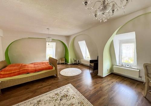 Schlafzimmer mit Nischenfenstern und Kronleuchter