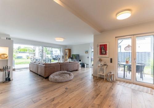 Wohnbereich mit Kamin und mehreren Zugängen zum liebevoll angelegten Garten