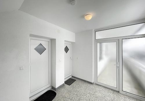 Freundlicher Treppenhausflur mit modernen Wohnungstüren