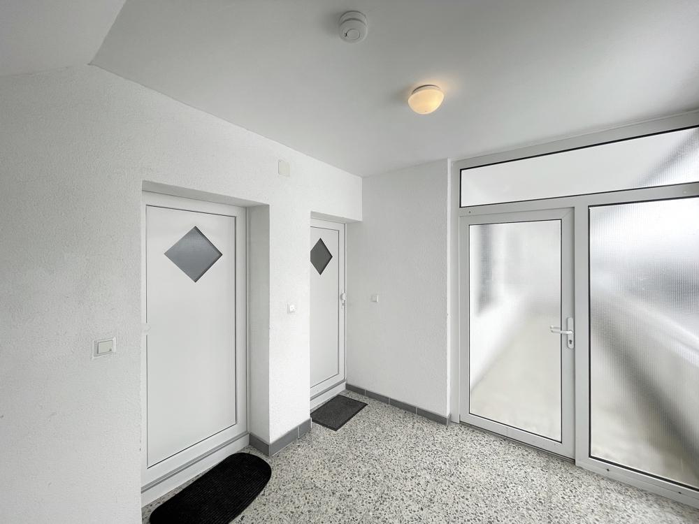 Freundlicher Treppenhausflur mit modernen Wohnungstüren