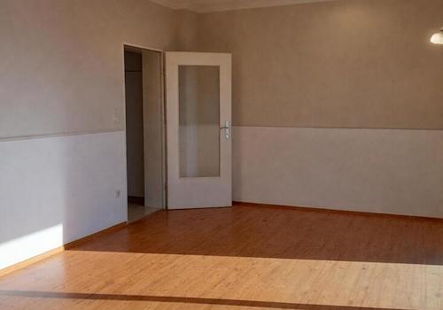 Helles Zimmer mit Holzfußboden und Tür