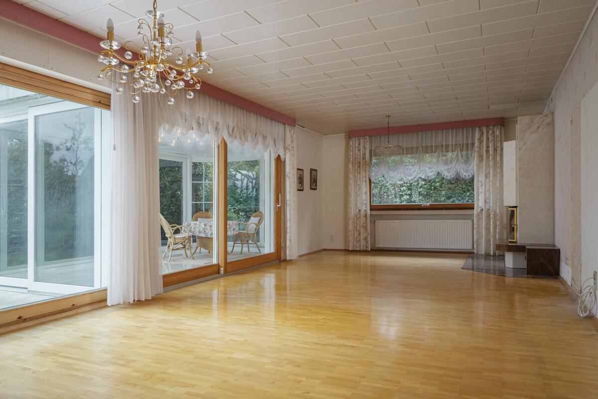 Das Wohnzimmer mit Kamin und dem Wintergarten