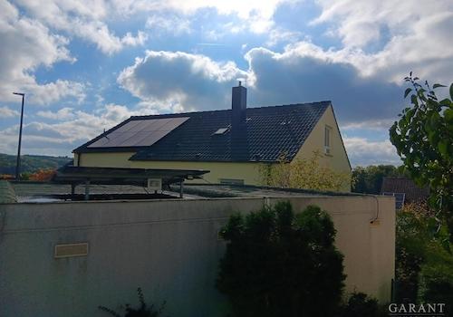 Hausansicht Eingangsseite mit PV-Anlage und Garage
