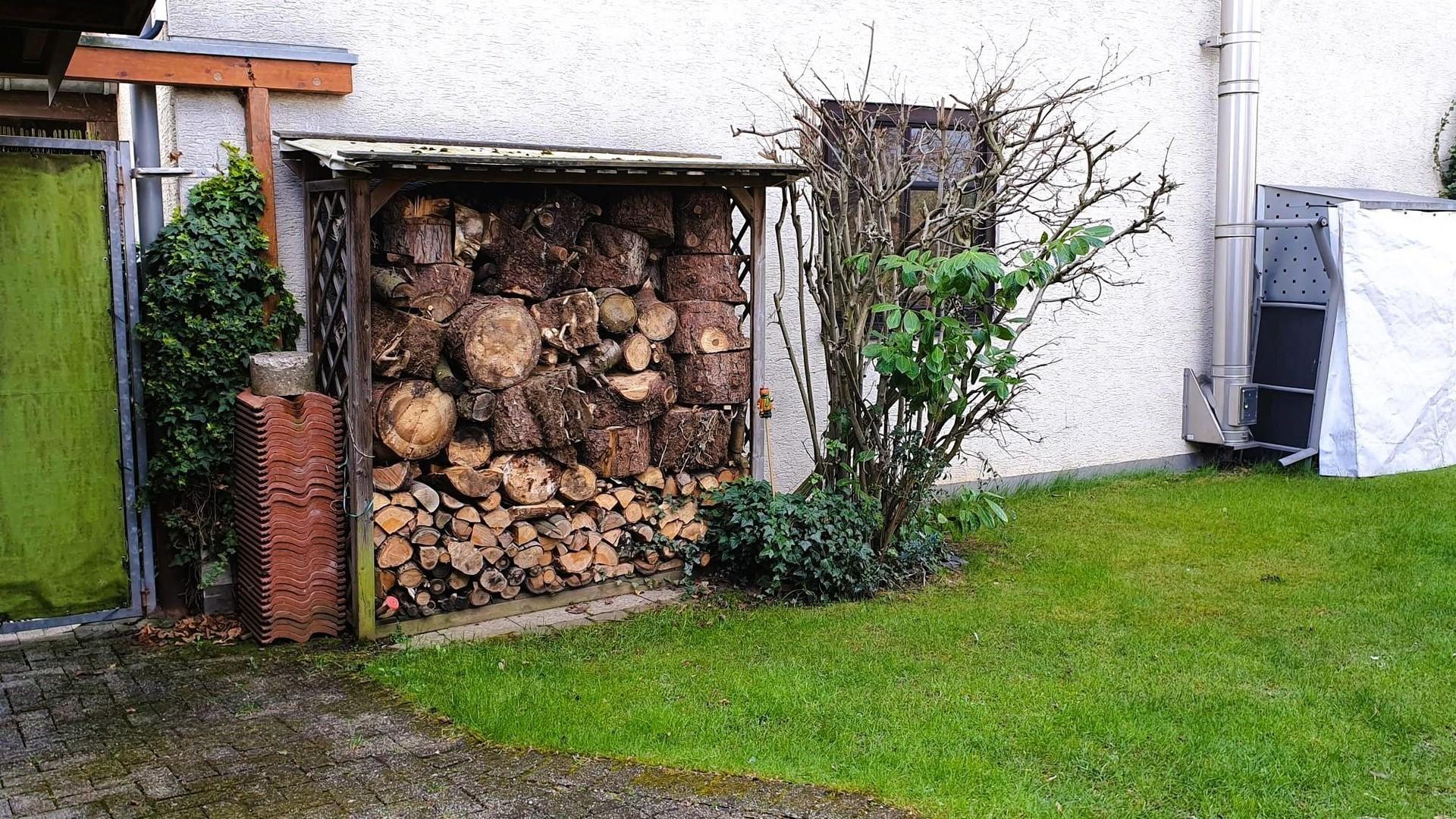 Garteneingang mit Holzlagern
