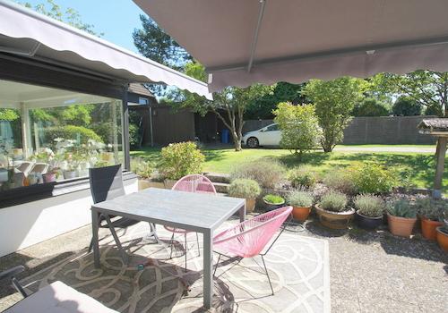 Blick auf Terrasse mit 2 Markisen, Carport u. Wintergarten