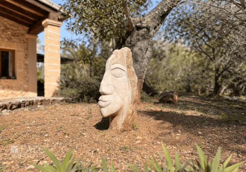 Steinerne Gesichtsskulptur im Garten