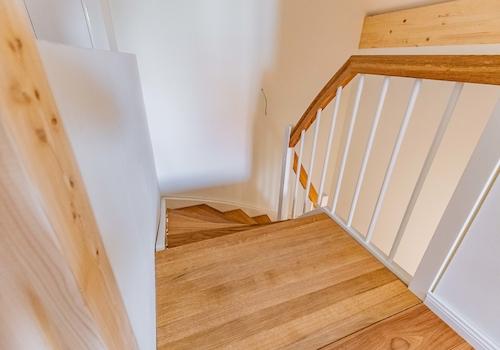 Eichentreppe mit Omegahandlauf und weißen Setzstufen