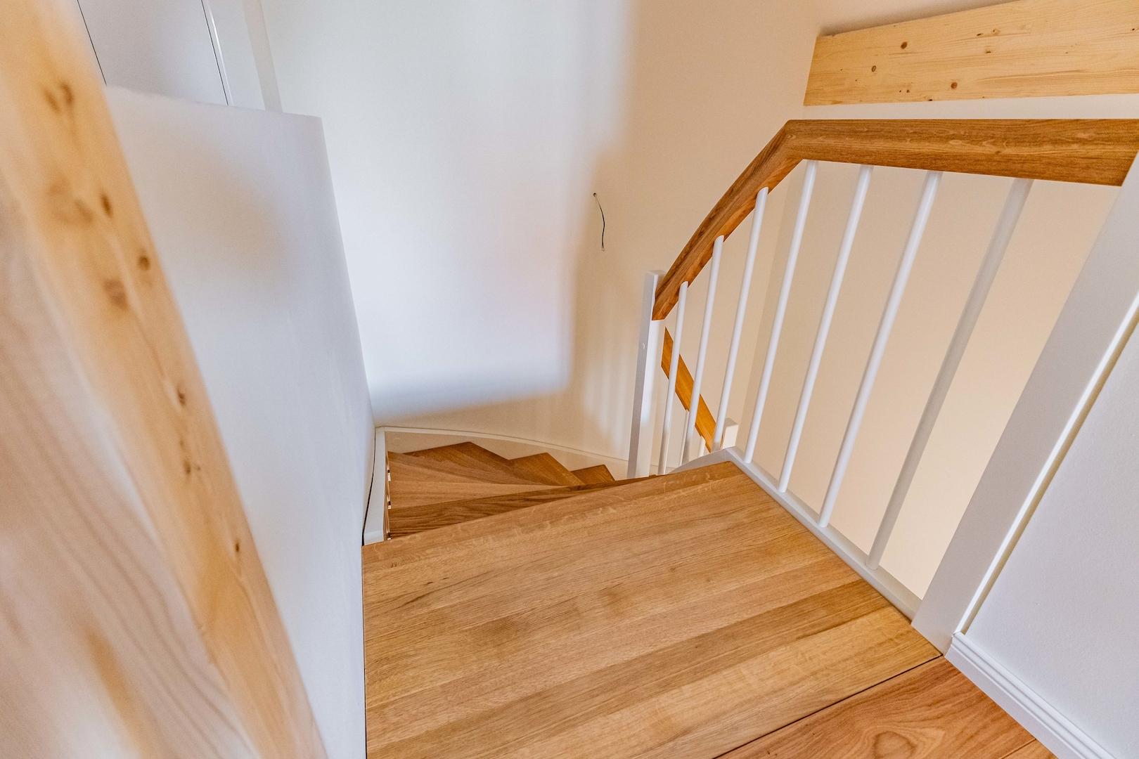 Eichentreppe mit Omegahandlauf und weißen Setzstufen