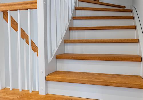 Eichentreppe mit Omegahandlauf und weißen Setzstufen