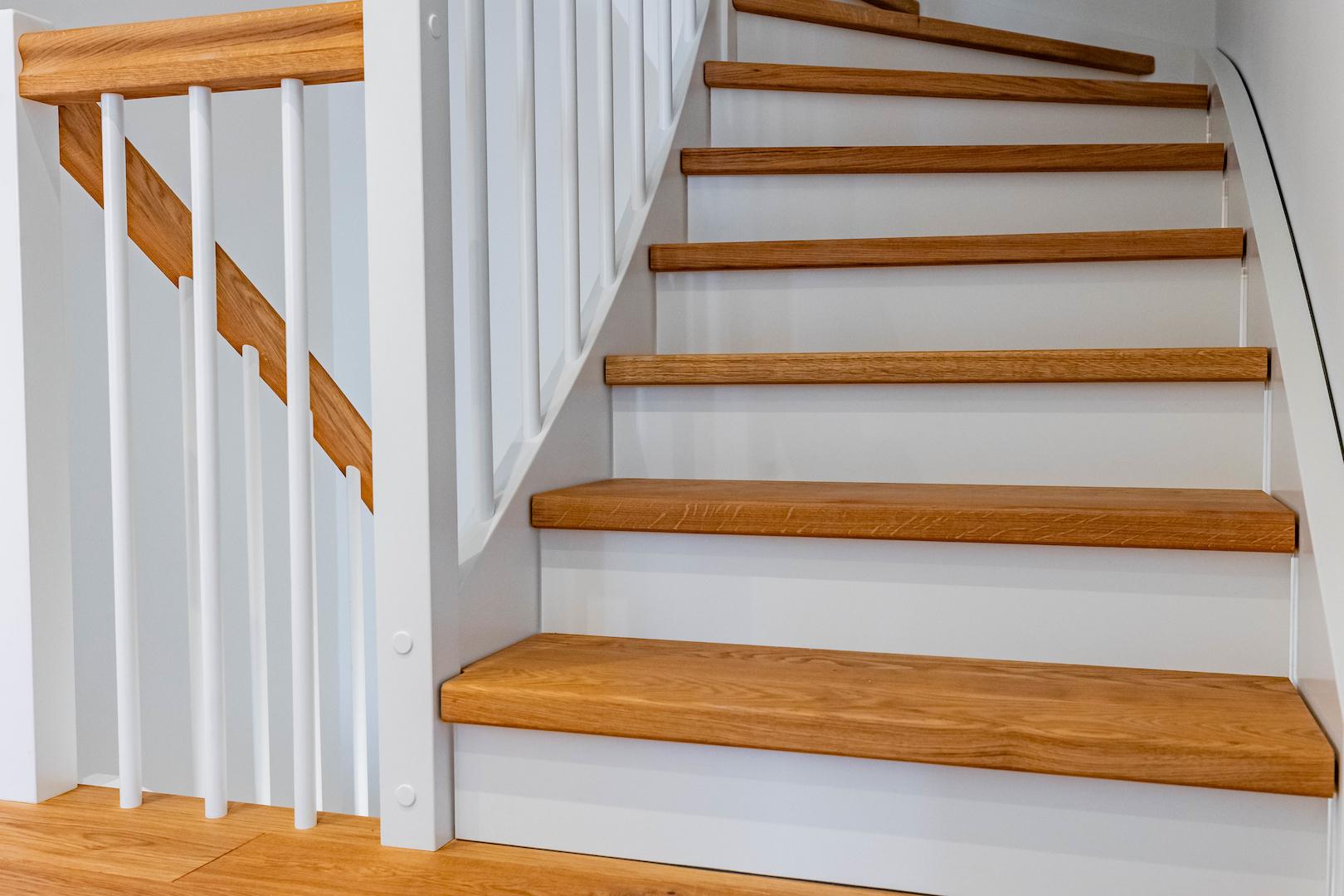 Eichentreppe mit Omegahandlauf und weißen Setzstufen