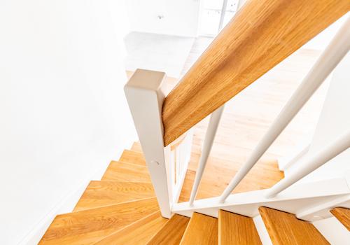 Eichentreppe mit Omegahandlauf und weißen Setzstufen