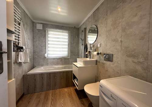 Badezimmer mit Badewanne, Fenster, WM-Anschluss und WC