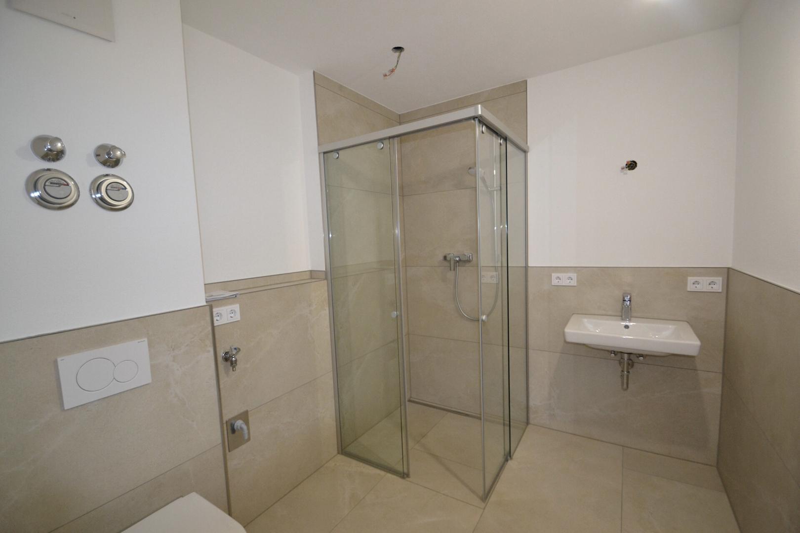 Badezimmer mit ebenerdiger Dusche und WAMA-Anschluss