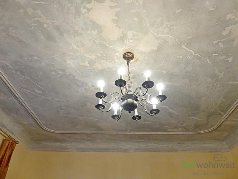 Kronenleuchter und bemalte Stuckdecke