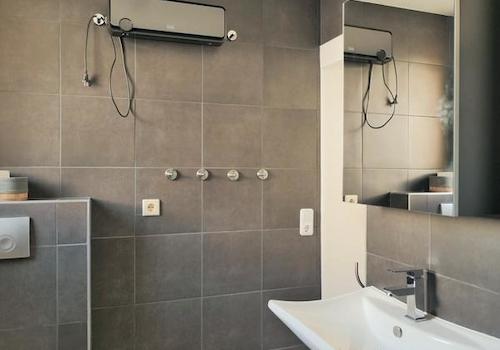 modernes Bad mit dunklen Fliesen