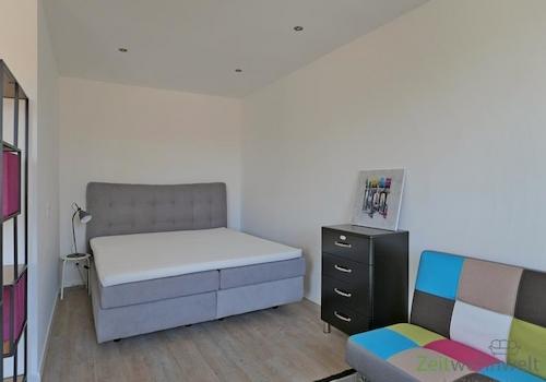 breites Bett hinter dem Raumteiler