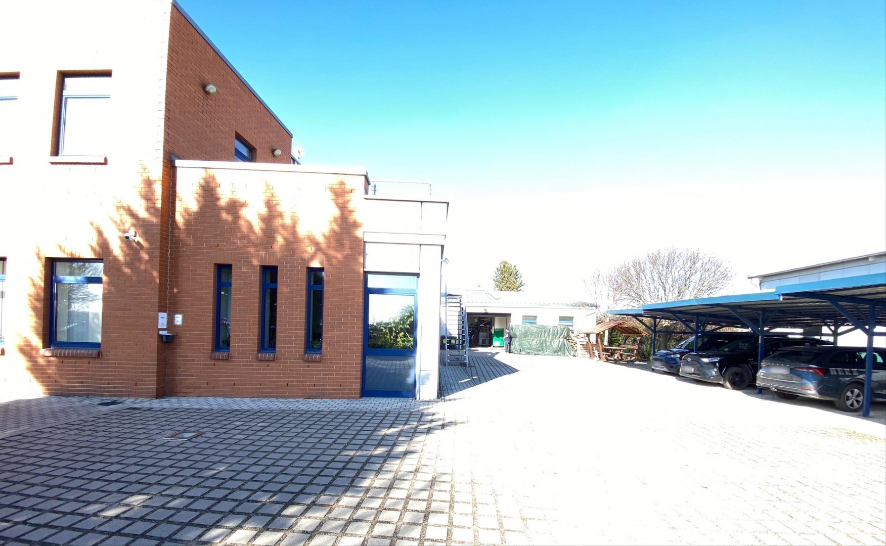 Ansicht mit Treppe zu dem Büros im Obergeschoss und Carports