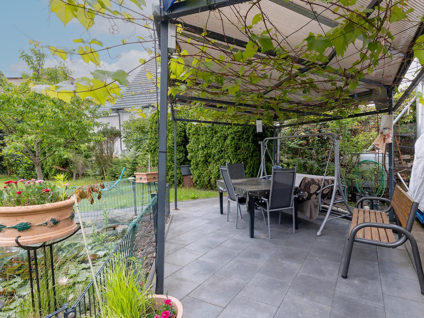 Überdachte Terrasse mit Blick ins grüne Gartengrundstück