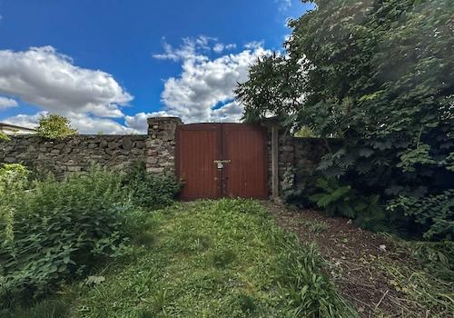 Historisches Hoftor mit Natursteinmauer