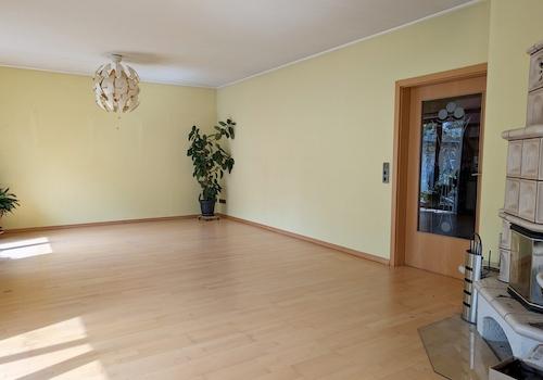 Wohnzimmer mit Kachelofen und direktem Zugang zu Sommergarten