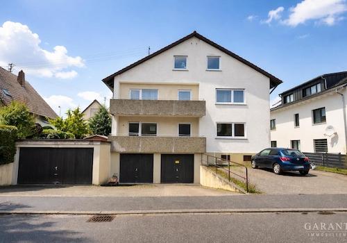 Helles Haus mit schwarzen Garagentoren